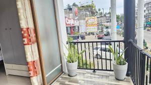 a balcony with two potted plants on a city street at Three Elements Mirissa in Mirissa