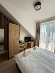 a bedroom with a bed with two towels on it at Stay at Royal Kraków Golf in Ochmanów +33 photos