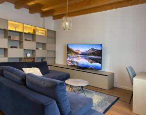 a living room with a blue couch and a flat screen tv at Casa Rinata in Novigrad Istria