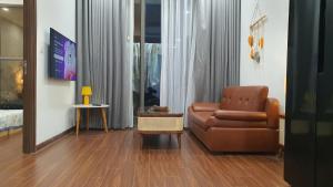 a living room with a couch and a chair at Capsule Masterise Vinhomes in Gia Lâm Pho