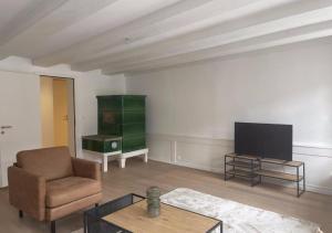 un soggiorno con sedia e TV di The R Apartment Bodensee - Old Town a Schaffhausen
