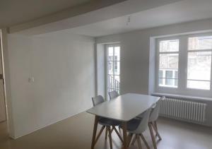 una sala da pranzo con tavolo, sedie e una finestra di The R Apartment Bodensee - Old Town a Schaffhausen