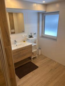 a bathroom with a sink and a mirror at MyAlpenloft 1 in Deutschgriffen +29 photos