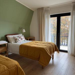 een slaapkamer met twee bedden en een groot raam bij Villa Angelina in Aquino