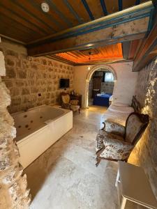 a room with a bath tub in a stone wall at Era Cappadocia in Uçhisar
