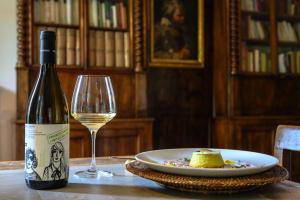 a bottle of white wine and a plate of cheese at Corte Massimago in Mezzane di Sotto