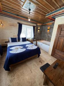 a bedroom with a large bed with a blue blanket at Era Cappadocia in Uçhisar