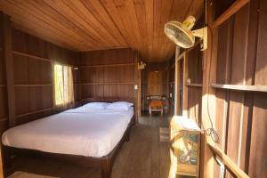 a bedroom with a bed in a wooden room at nam jai pai in Ban Wiang Nua
