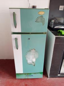 an old refrigerator with a bird painted on it at Menik's place in Mirissa