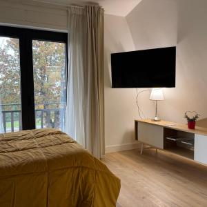 een slaapkamer met een bed en een televisie aan de muur bij Villa Angelina in Aquino