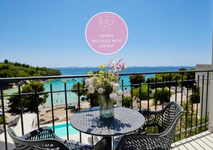 a table with a vase of flowers on a balcony at Colentum Resort Murter in Murter