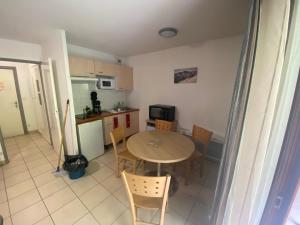 a kitchen with a table and chairs in a room at Appartement 4 couchages in Arreau
