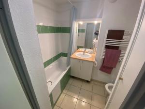 a bathroom with a sink and a tub and a toilet at Appartement 4 couchages in Arreau +7 photos