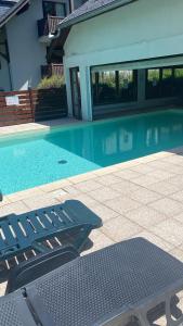 a swimming pool with a bench next to a house at Appartement 4 couchages in Arreau