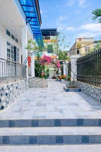 een loopbrug buiten een gebouw met bloemen bij Bảo Ngọc Motel in Ha Giang