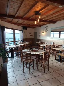 un ristorante con tavoli e sedie e un orologio sul muro di Camping Pommiers des Trois Pays a Licques