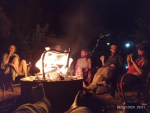 a group of people sitting around a fire at night at nam jai pai in Ban Wiang Nua