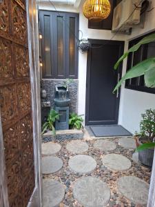 a door to a house with a stone walkway at Hello Tourist Residence in Quatre Bornes