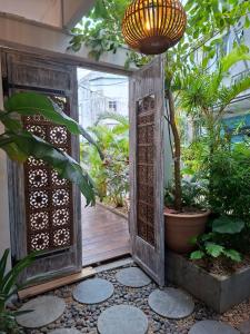 an open wooden door in a garden with plants at Hello Tourist Residence in Quatre Bornes