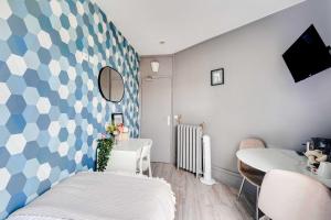 een slaapkamer met een blauw-wit geblokte muur bij Modern studio - 1P- Canal Saint-Martin in Parijs