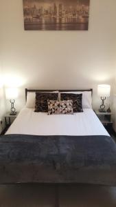 een slaapkamer met een groot wit bed met twee lampen bij City Centre Apt, Prime location, Sleeps 3 in Midland