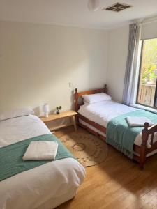 En eller flere senge i et værelse på Delight On Downer - Coastal Family Escape