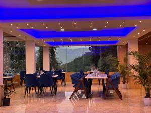 a restaurant with tables and chairs and a blue ceiling at Wisteria Crystal Manor in Pelling