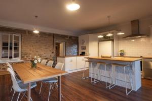 a kitchen with a wooden table and a dining room at Thedell Cottage - A Boutique Heritage Escape in Auburn