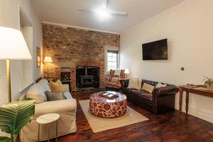a living room with a couch and a table at Thedell Cottage - A Boutique Heritage Escape in Auburn