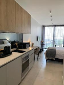 a kitchen and a bedroom with a bed in a room at Ellipse Luxurious Tamarind Red Studio Experience in Midrand