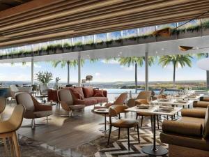 a restaurant with tables and chairs and a view of the ocean at Ellipse Luxurious Tamarind Red Studio Experience in Midrand