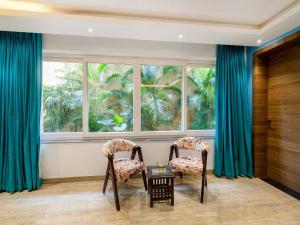 two chairs and a table in front of a window at Villa Vana By DanCenter | 5BHK | Pvt Pool | Baga Beach, GOA in Arpora