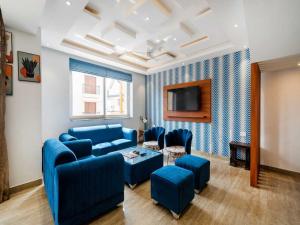 a living room with blue couches and a tv at Villa Vana By DanCenter | 5BHK | Pvt Pool | Baga Beach, GOA in Arpora