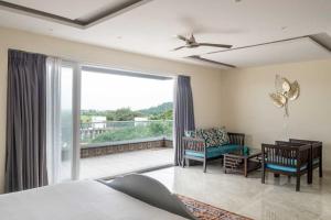 a bedroom with a bed and a couch and a balcony at Villa Vana By DanCenter | 5BHK | Pvt Pool | Baga Beach, GOA in Arpora +52 photos