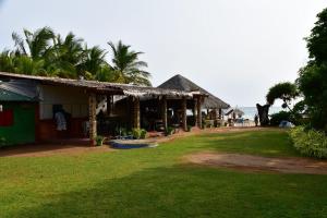 a house with a grass yard next to a building at Thats why beach hotel in Trincomalee