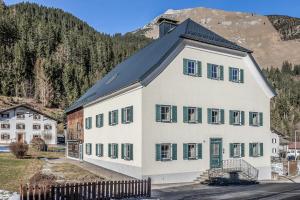 een groot wit gebouw met een zwart dak bij Chalet Bauernhaus 1864 in Elbigenalp