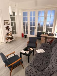 un soggiorno con divano, sedie e finestre di The Horse Monument Hostel a Belgrado