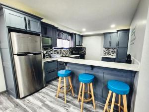 a kitchen with blue stools at a counter at Tobago Tropical Hideaway in Lowlands
