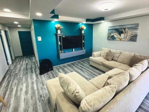 a living room with a couch and a tv at Tobago Tropical Hideaway in Lowlands