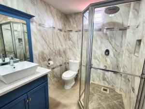 a bathroom with a toilet and a sink and a shower at Tobago Tropical Hideaway in Lowlands