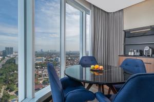 a dining room with a table and blue chairs at Novotel Jakarta Pulo Mas in Jakarta