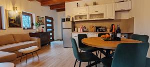 a kitchen and a living room with a table and chairs at CaSa ViTo Kumrovec in Brezje
