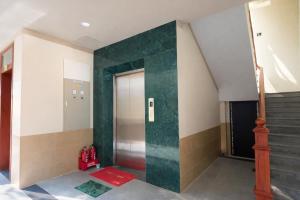 a hallway with a green door and stairs at Khách Sạn - Cà Phê Dinh Cô in Long Hai