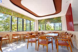 a restaurant with tables and chairs and windows at Khách Sạn - Cà Phê Dinh Cô in Long Hai