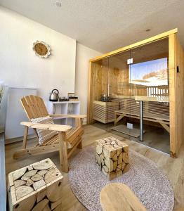 een woonkamer met een tafel en een stoel bij Le Balcon des Ecrins in Réallon