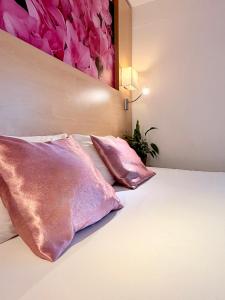 een slaapkamer met twee kussens op een bed met een schilderij bij Fasthotel Orleans Zénith in Orléans