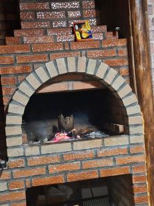 a brick oven with a fire inside of it at CĂSUȚA BUNICII CU PRISPĂ in Dospineşti