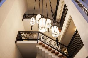 an image of a staircase with chandeliers at Narinthra Heritage in Chiang Mai