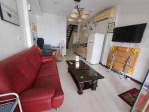 a living room with a red couch and a table at House of love in Xiaoliuqiu