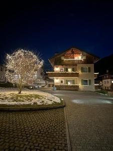 un edificio con un albero con luci davanti di Casa Le Rondini a Valdisotto